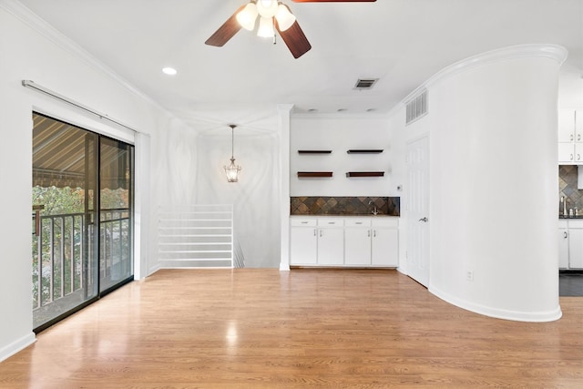 unfurnished living room with light hardwood / wood-style floors, ceiling fan, and crown molding