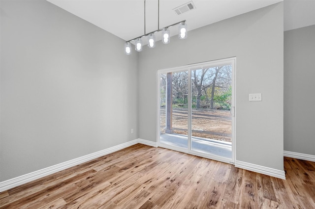 unfurnished dining area with rail lighting and hardwood / wood-style floors