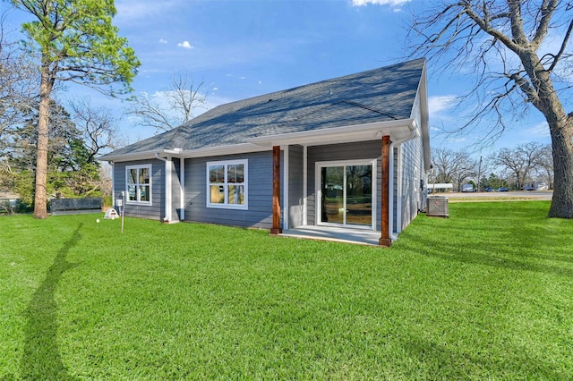 rear view of property featuring a lawn and central air condition unit