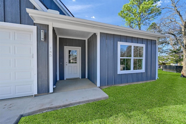 doorway to property featuring a yard and a garage