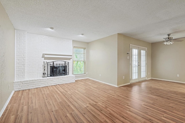 unfurnished living room featuring a fireplace, wood-type flooring, a textured ceiling, and ceiling fan