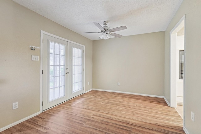 spare room with ceiling fan, light wood-type flooring, a textured ceiling, and french doors