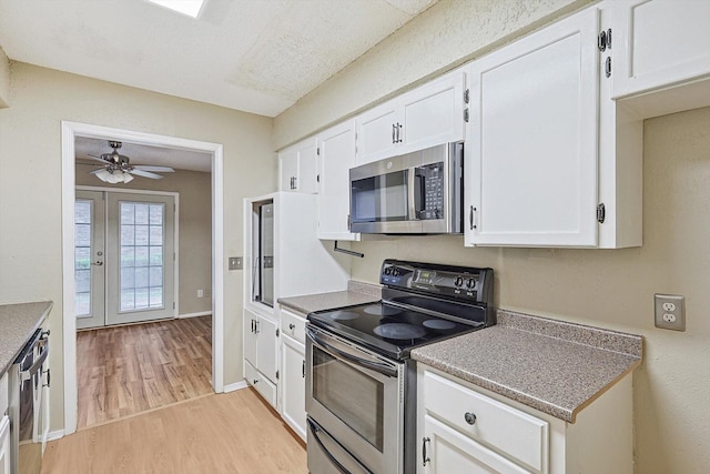 kitchen with white cabinetry, french doors, ceiling fan, light hardwood / wood-style floors, and appliances with stainless steel finishes