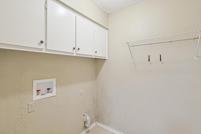 laundry area with cabinets, a textured ceiling, and hookup for a washing machine