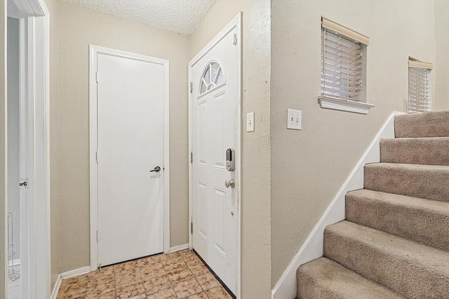 foyer entrance with a textured ceiling