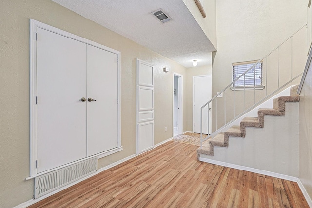 foyer featuring light hardwood / wood-style flooring and a textured ceiling