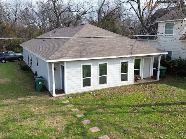 back of property featuring a lawn