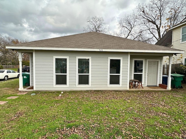 rear view of property featuring a lawn