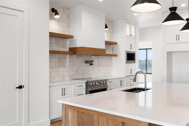 kitchen featuring decorative backsplash, appliances with stainless steel finishes, open shelves, and a sink