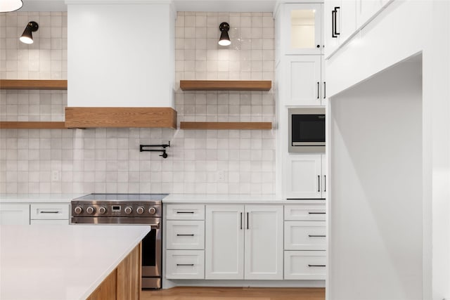 kitchen featuring open shelves, tasteful backsplash, light countertops, appliances with stainless steel finishes, and white cabinetry