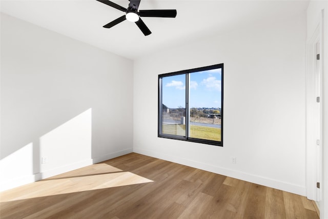 spare room featuring a ceiling fan, baseboards, and wood finished floors