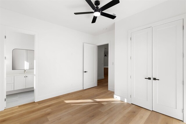 unfurnished bedroom with light wood-type flooring, baseboards, a closet, and ensuite bathroom