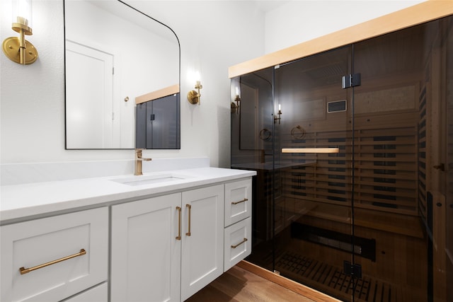 bathroom featuring a sauna, vanity, wood finished floors, and a stall shower