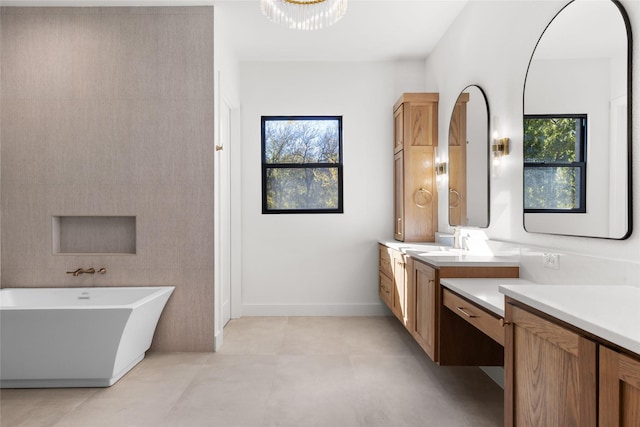 full bath featuring baseboards, plenty of natural light, vanity, and a freestanding bath