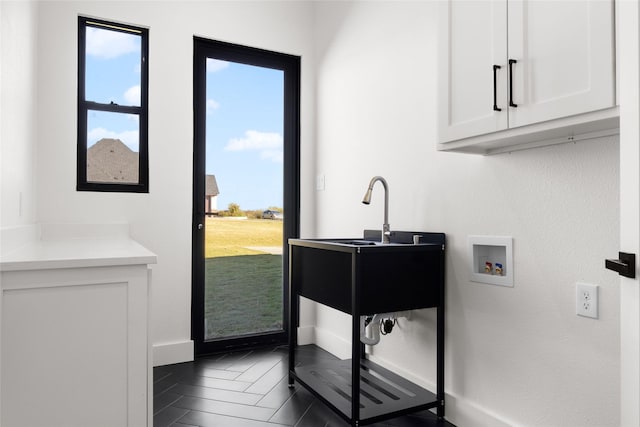 interior space featuring baseboards, light countertops, and white cabinets