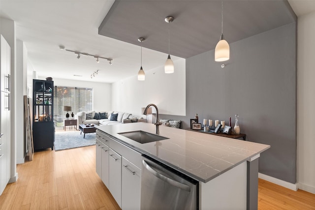 kitchen with white cabinetry, dishwasher, sink, hanging light fixtures, and a kitchen island with sink