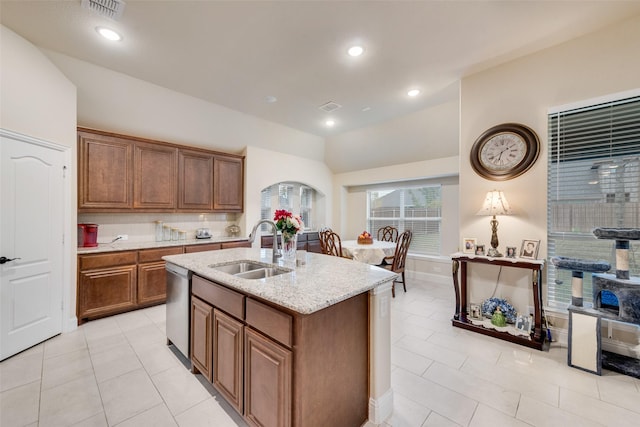 kitchen featuring sink, a kitchen island with sink, backsplash, vaulted ceiling, and stainless steel dishwasher