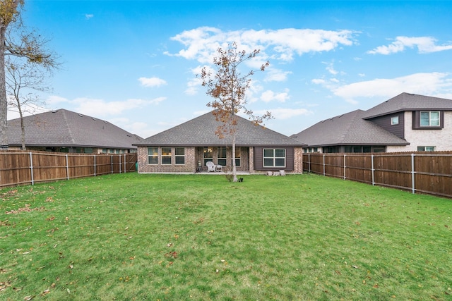 rear view of property featuring a yard