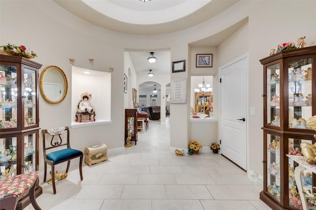 entrance foyer featuring ceiling fan with notable chandelier and light tile patterned floors