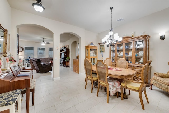 tiled dining space with ceiling fan with notable chandelier