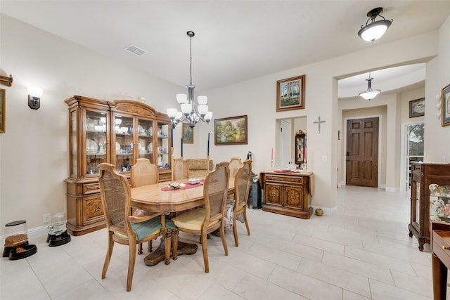 tiled dining room featuring a chandelier