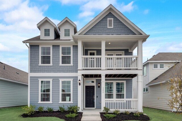 view of front of property with a balcony, a front lawn, and a porch