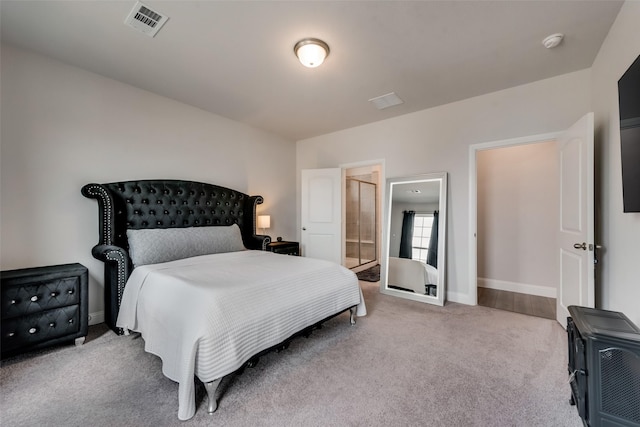 bedroom with light carpet and connected bathroom