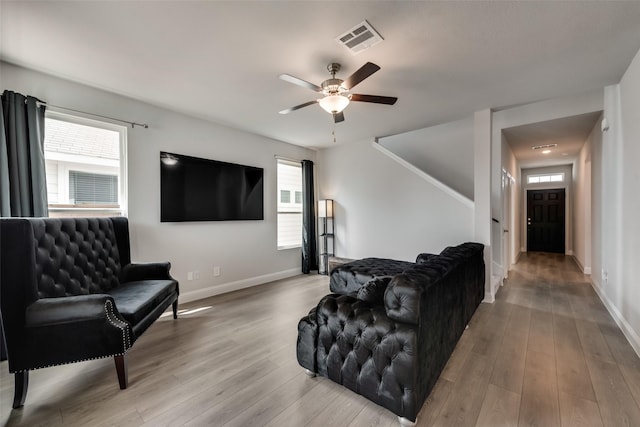 living room featuring hardwood / wood-style floors and ceiling fan