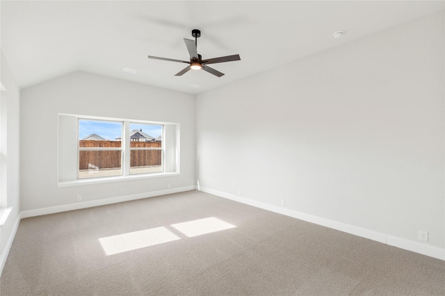 empty room with vaulted ceiling, light colored carpet, and ceiling fan