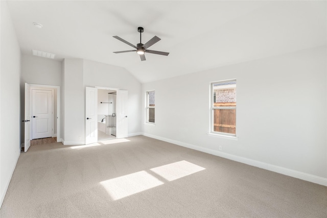 unfurnished bedroom featuring ensuite bathroom, lofted ceiling, light carpet, and ceiling fan