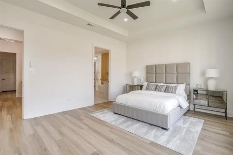 192 Top Flight Dr, Weatherford, TX 76087 - bedroom with ceiling fan, baseboards, wood finished floors, a tray ceiling, and visible vents