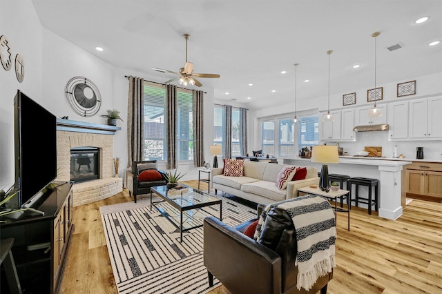 living room with plenty of natural light, ceiling fan, and light hardwood / wood-style floors