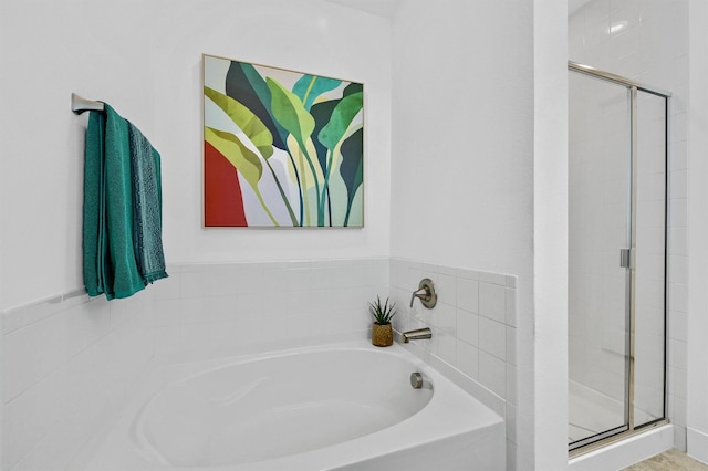 bathroom featuring shower with separate bathtub