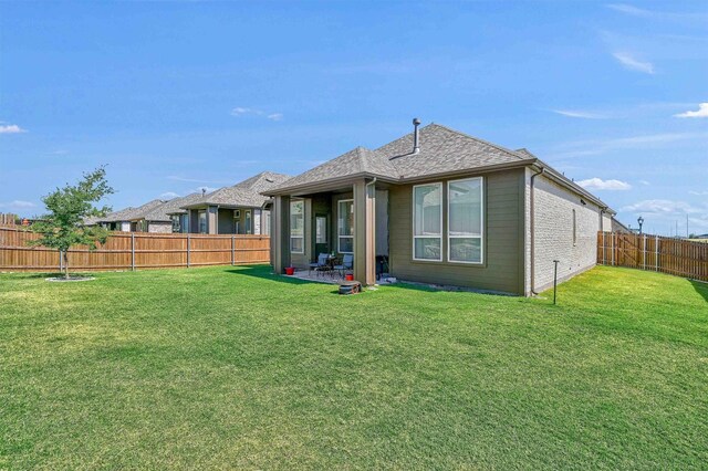 back of property featuring a patio area and a yard