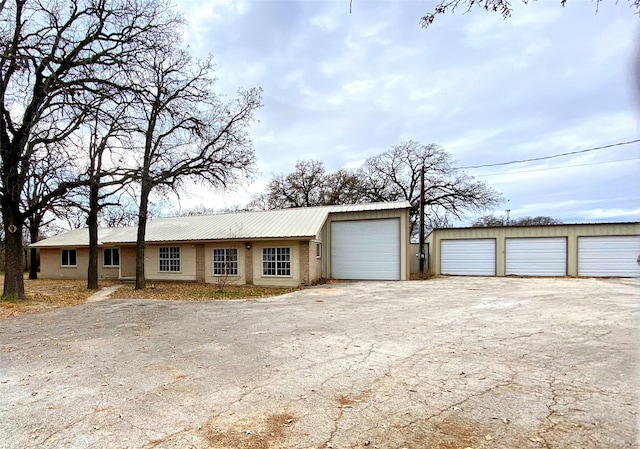 ranch-style house featuring a garage and an outbuilding