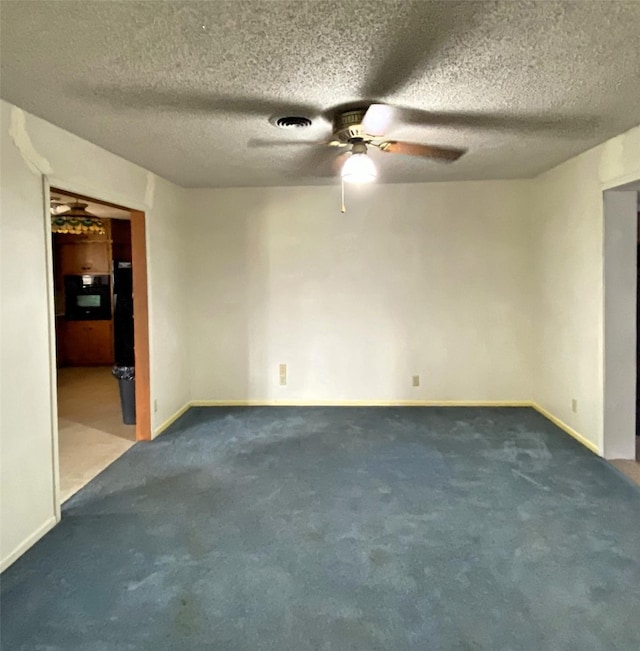 carpeted empty room featuring a textured ceiling and ceiling fan