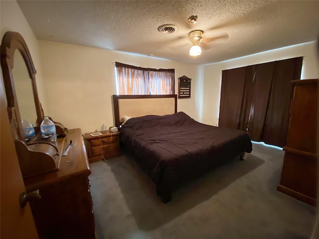 carpeted bedroom with ceiling fan and a textured ceiling