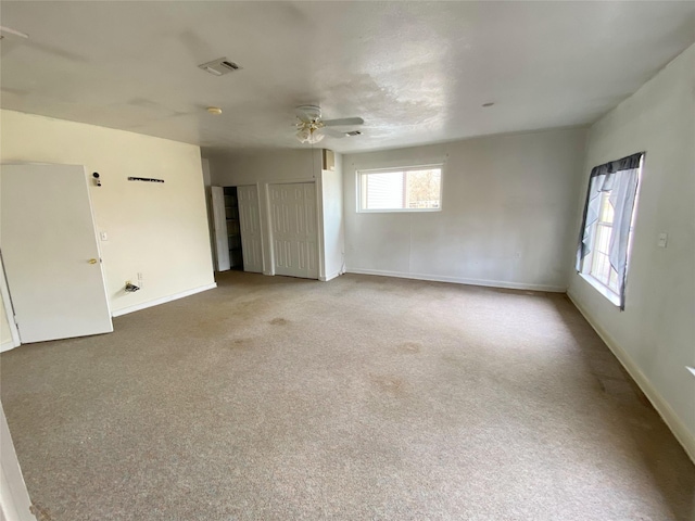 carpeted spare room featuring ceiling fan