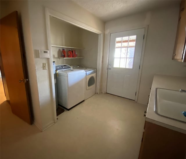 washroom with separate washer and dryer, sink, and a textured ceiling