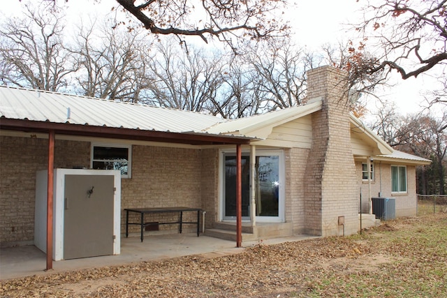 rear view of house featuring cooling unit and a patio