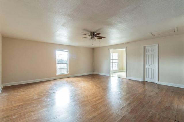 spare room with ceiling fan, a textured ceiling, and light hardwood / wood-style flooring