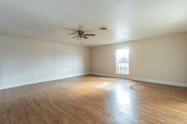 spare room with a textured ceiling, light hardwood / wood-style floors, and ceiling fan