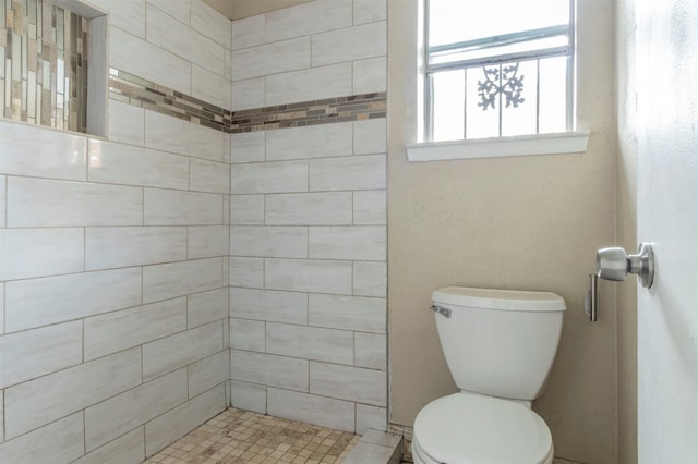 bathroom featuring toilet and tiled shower