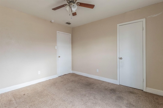 carpeted spare room featuring ceiling fan