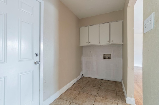 laundry room featuring hookup for a washing machine, light tile patterned flooring, and cabinets