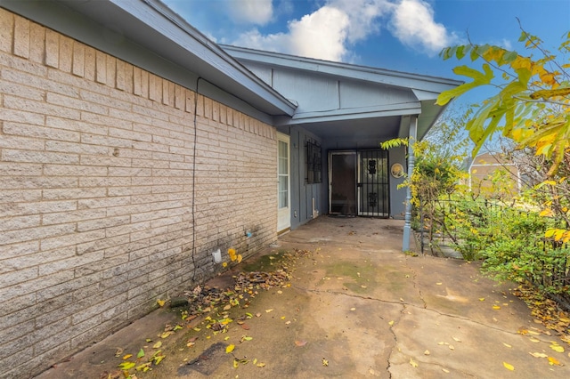 view of exterior entry with a patio