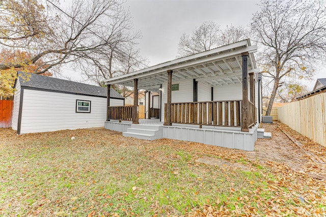 back of house featuring a porch, a yard, and central AC unit