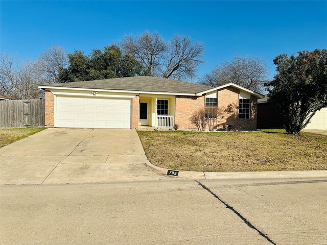 single story home with a porch, a front yard, and a garage