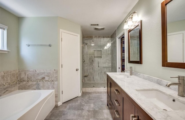 bathroom with vanity and shower with separate bathtub