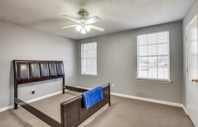 bedroom featuring multiple windows, a textured ceiling, and carpet